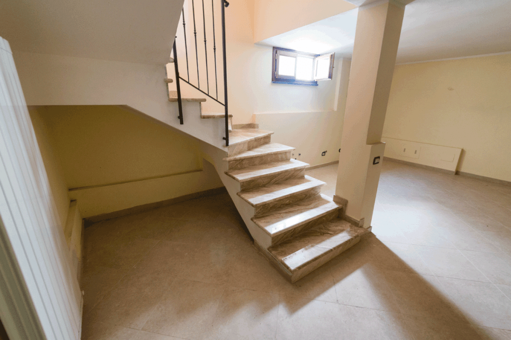 Staircase to basement room with a brightly lit window. Are Basement Apartments Cold Are They Cooler In Summer