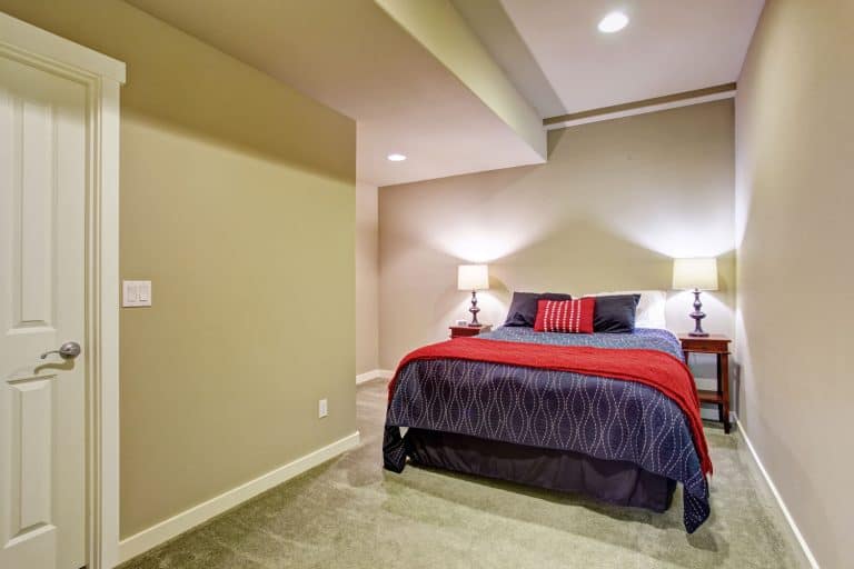 A small bedroom with recessed lighting, cream walls and colorful beddings, Can I Rent My Basement On Airbnb?