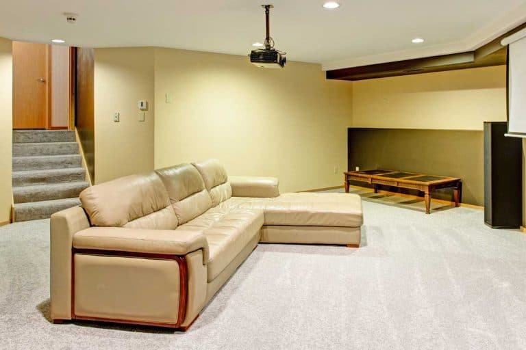 Beige basement movie room with a leather sectional, How To Soundproof A Basement Apartment