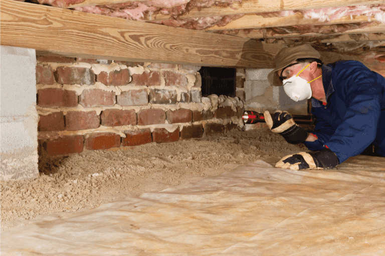 Termite inspector in residential crawl space inspects a foundation for termites. Can You Convert A Crawl Space Into A Basement