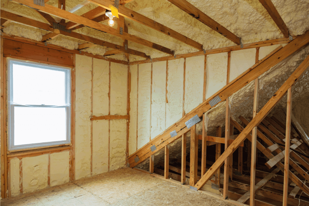 A room at newly constructed home is sprayed with liquid insulating foam. How To Insulate Under Basement Stairs