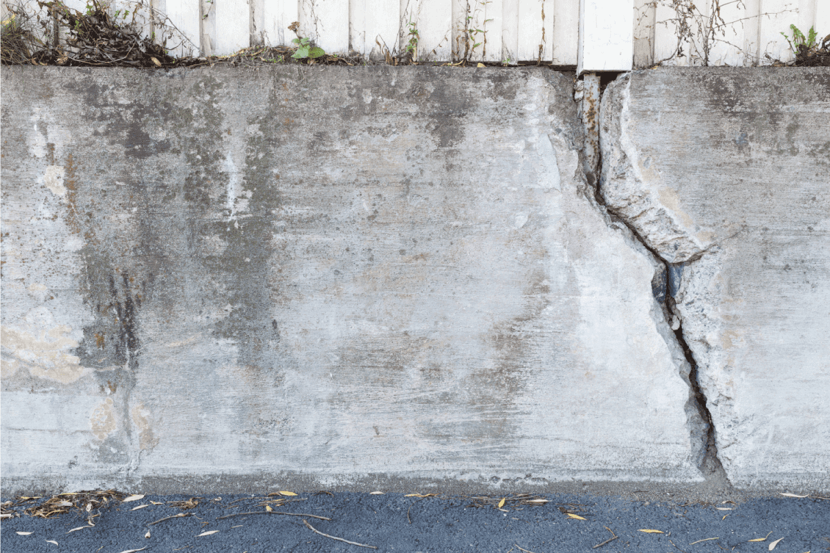 Big crack in messy concrete wall