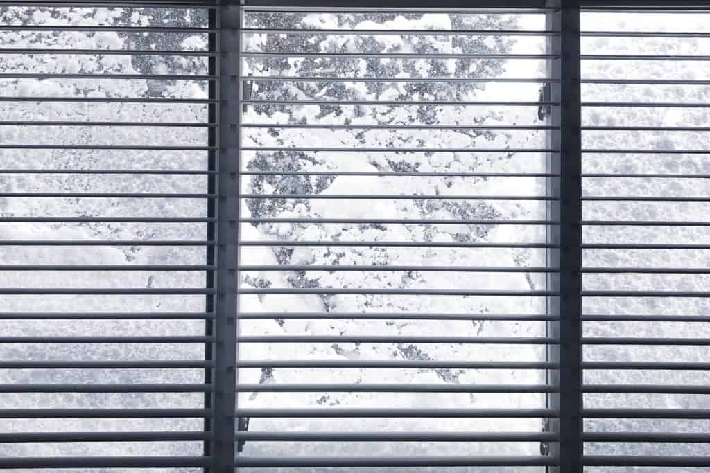 Wide-image-of-frozen-outdoor-conditions-through-a-window-blind