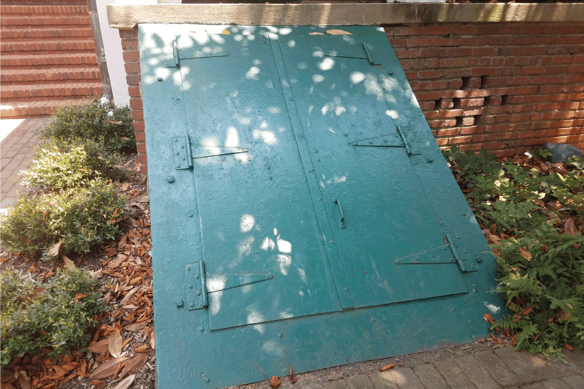 a green door leading into a basement or cellar, under the shade of trees. Are Bilco Doors Secure