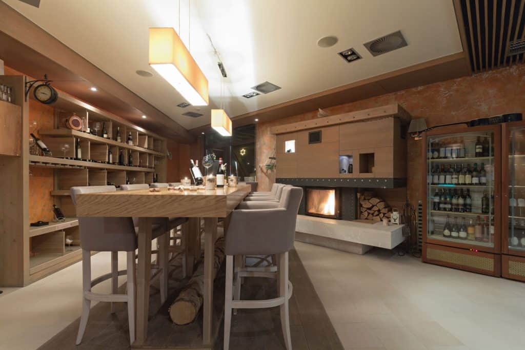 A dark and rustic inspired basement with a cellar and a small fireplace