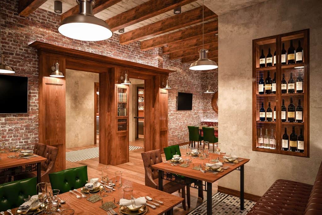 A large and high ceiling basement with wines stored in glass cabinets in the entertainment area