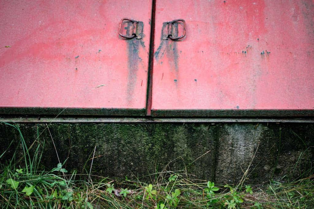A red colored Iron Bilco door