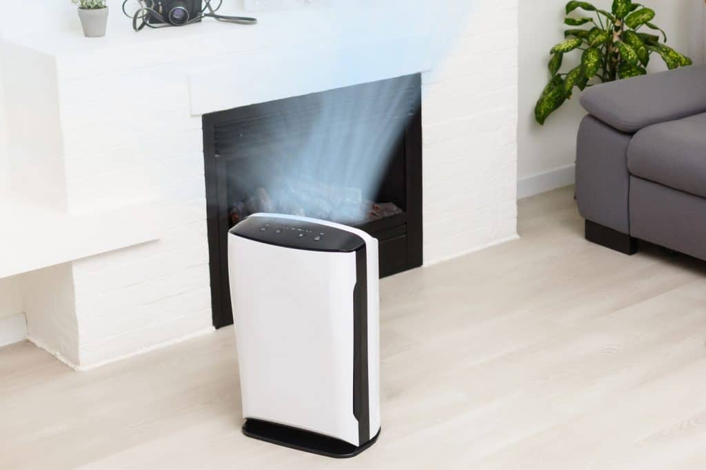 A small dehumidifier placed near the fireplace in the basement