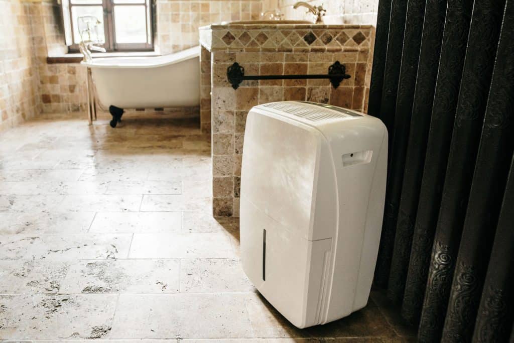 A small white dehumidifier in the center of the bathroom