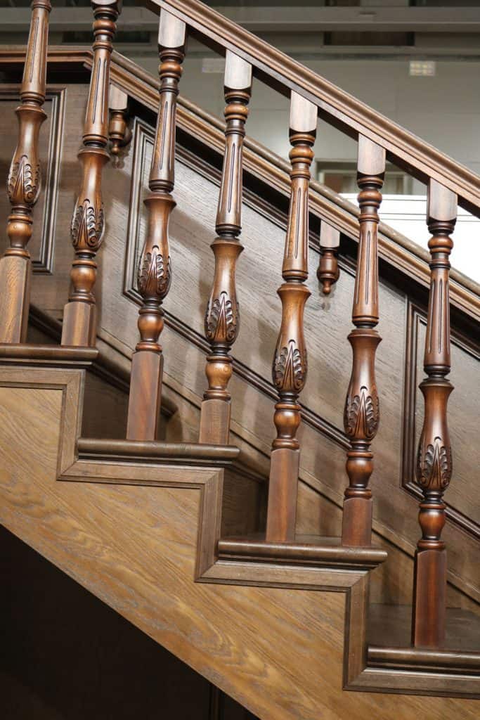 Gorgeous stair balusters and a brown stair stringer leading to the basement