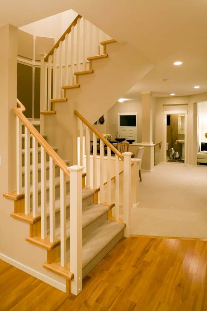 Rustic inspired basement with walls painted in tan colors with recessed lighting with runway carpet on the stairs