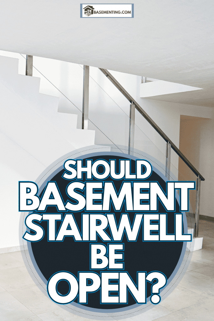 A concrete basement stairwell with metal railing