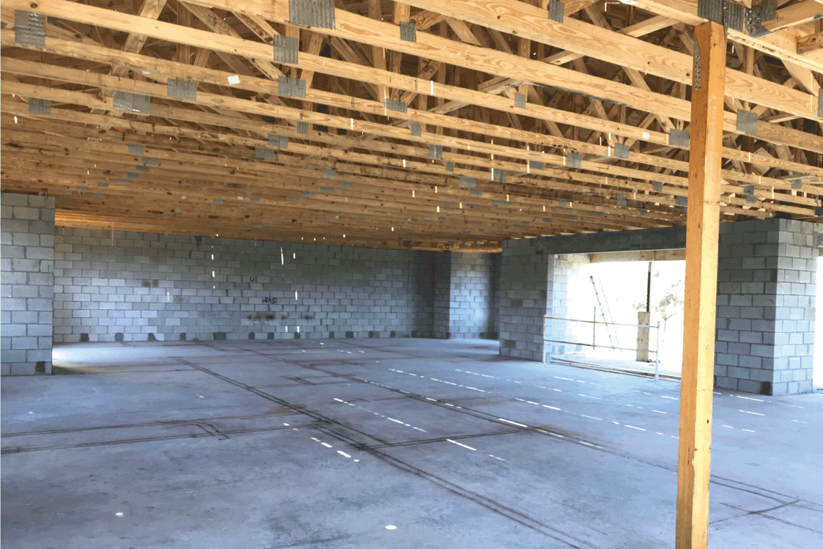 The exterior walls have been constructed on a new home. The interior walls have been drawn on the cement floor of the currently open-space.