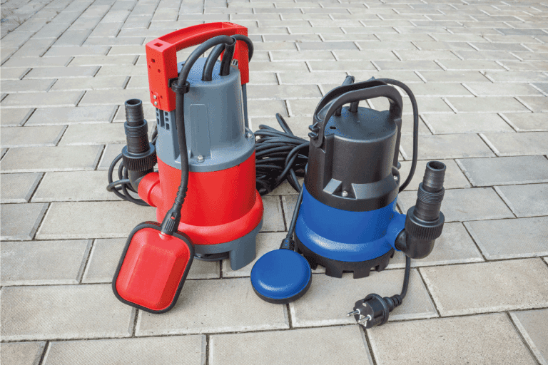 Two household submersible pump with plastic housings on stone floor of courtyard. How To Install The Basement Watchdog