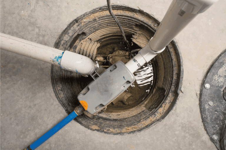 overhead photo of a sump pump installed in a collection tank in the basement. How To Relieve Hydrostatic Pressure In The Basement