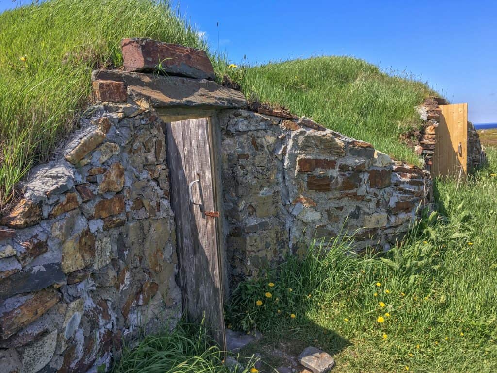 two root cellars in grassy hillside on Fogo Island, Newfoundland

