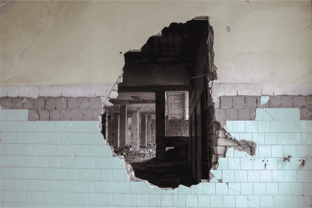 A hole in the wall of a large tiled building.