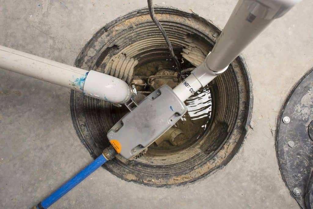 A sump pump installed in a basement of a home with a water powered backup system