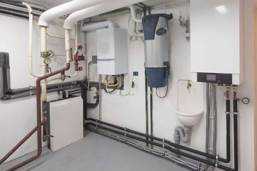 Interior of a boiler and water heater room filled with pipes and wires
