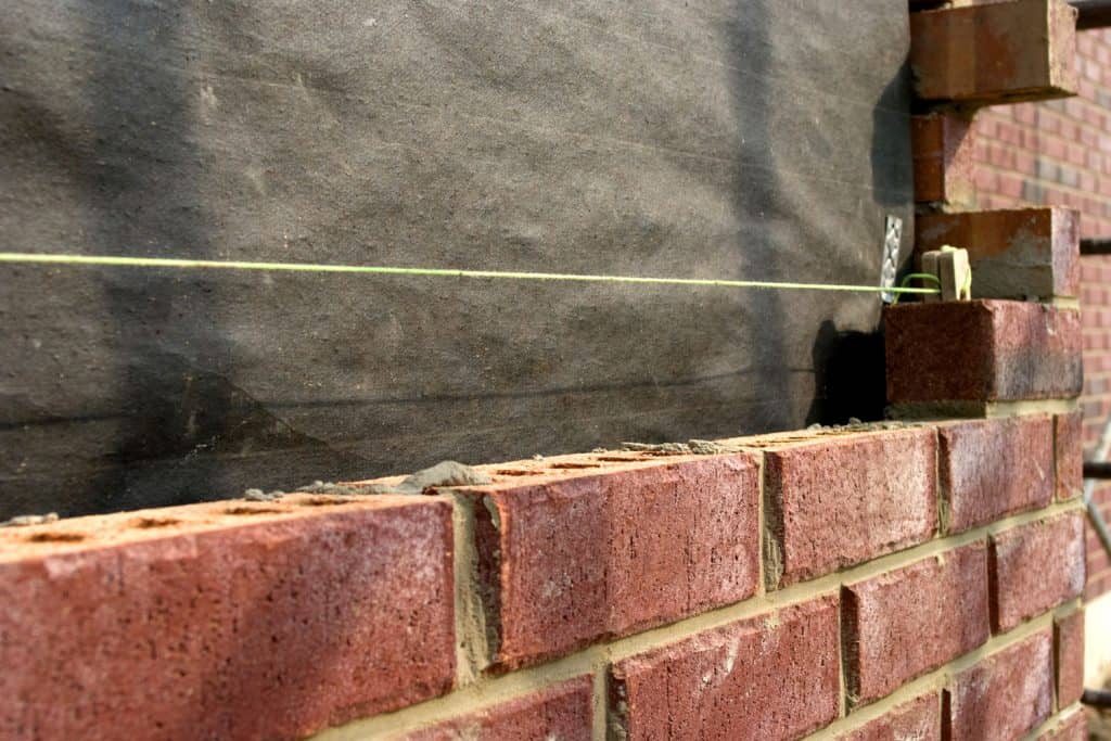Piled red bricks with a chalk line for masons to use as guide