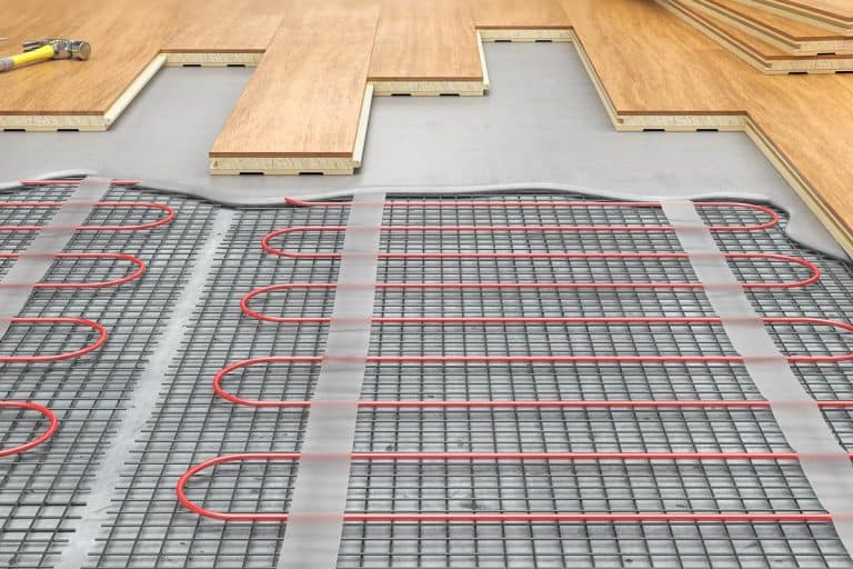 Process of laying parquet boards on floor with underfloor heating, Types Of Basement Floor Heating Systems [By Flooring Material]