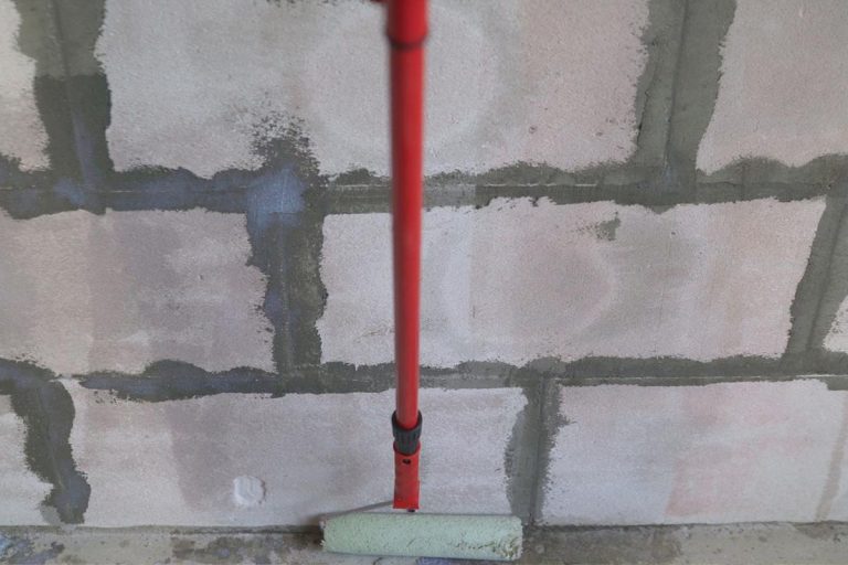 Roller application of waterproofing sealant to the wall, How Much Does B-Dry Basement Waterproofing Cost?