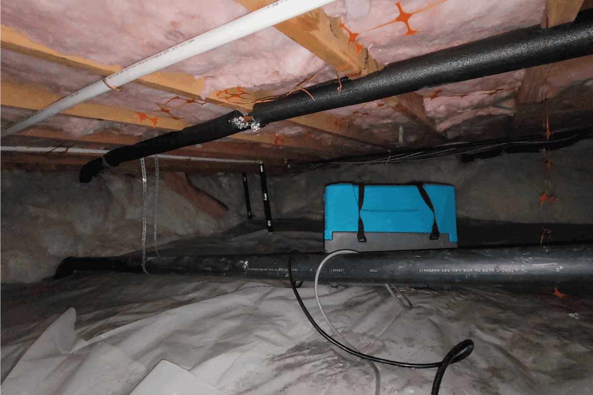 dehumidifier device inside a house crawlspace basement with furnace vents