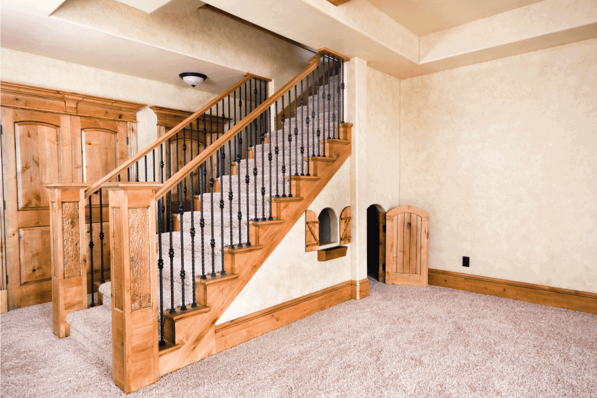 wooden basement stairs with beautiful metal railings