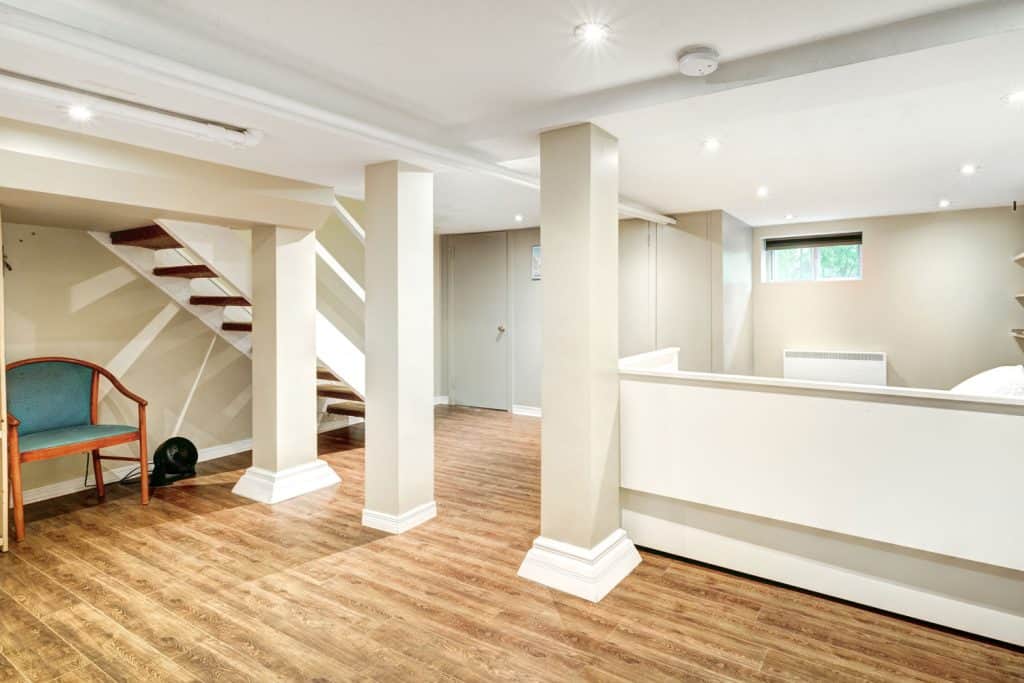 Basement with laminated flooring, white column posts and white ceiling with recessed lighting