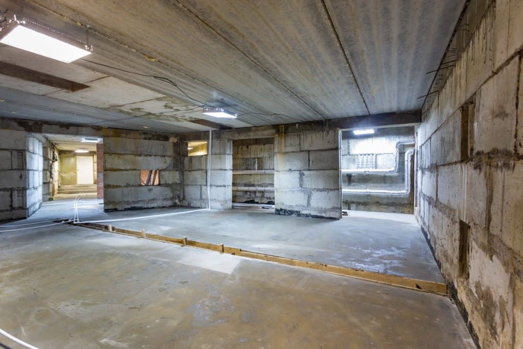 Interior of a basement under construction with unfinished walls and wooden moldings